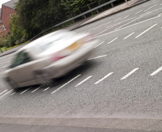 Blurred image of car speeding along road