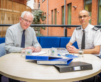 PCC Orpen Smellie sat round a table with Chief Constable Paul Sanford