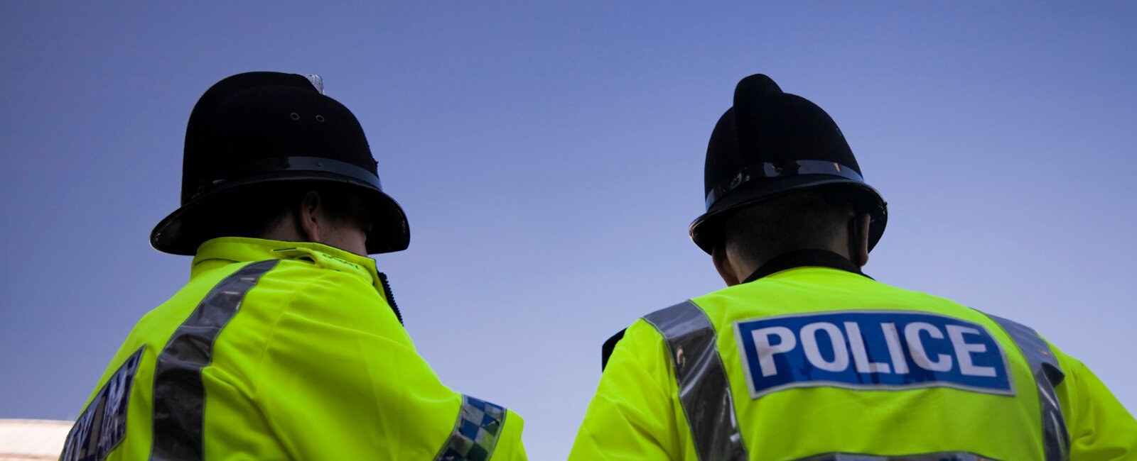 Backs of police officers in high-vis