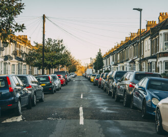 centre of urban street with cars parked either side of road