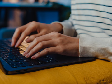 close up of female hands typing on a laptop keyboard