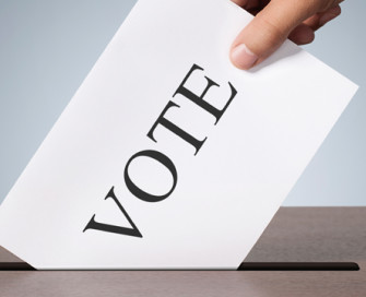 Voting card entering a ballot box