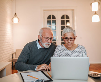 Mature couple looking at laptop at table