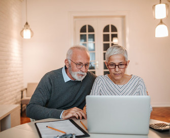 Mature couple looking at laptop at table