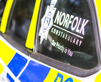 Side of police car with Norfolk Constabulary logo