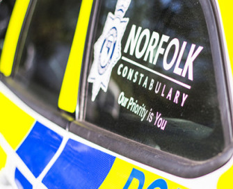 Side of police car with Norfolk Constabulary logo