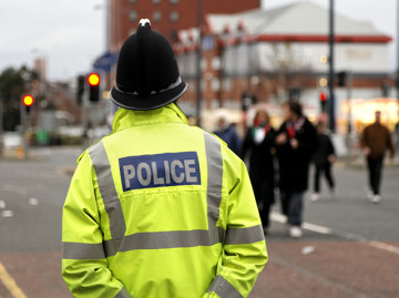 Back view of police officer outside wearing high visibility jacket 