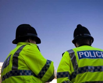Backs of two police officers wearing high visibility jackets