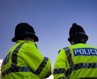 Backs of two police officers wearing high visibility jackets