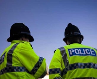 Backs of two police officers wearing high visibility jackets