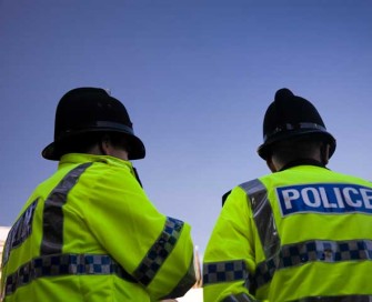 Backs of two police officers wearing high visibility jackets