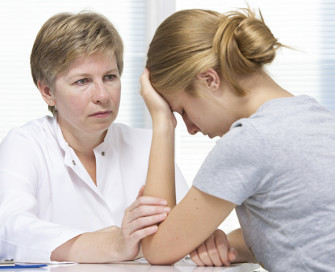 Female sat down counselling another female